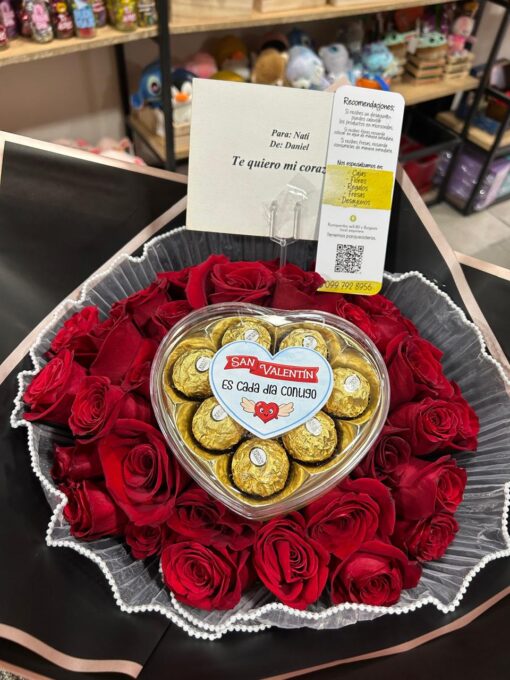 Ramo de rosas rojas con una caja de chocolates Ferrero Rocher en forma de corazón y una tarjeta de regalo personalizada.